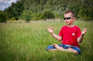 Boy with autism meditating to reduce stress 